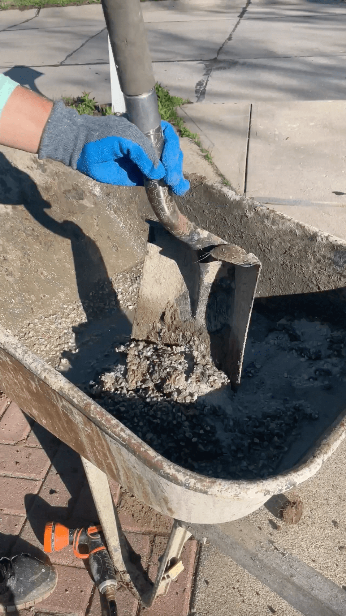 Mixing concrete in a wheel barrow. 
